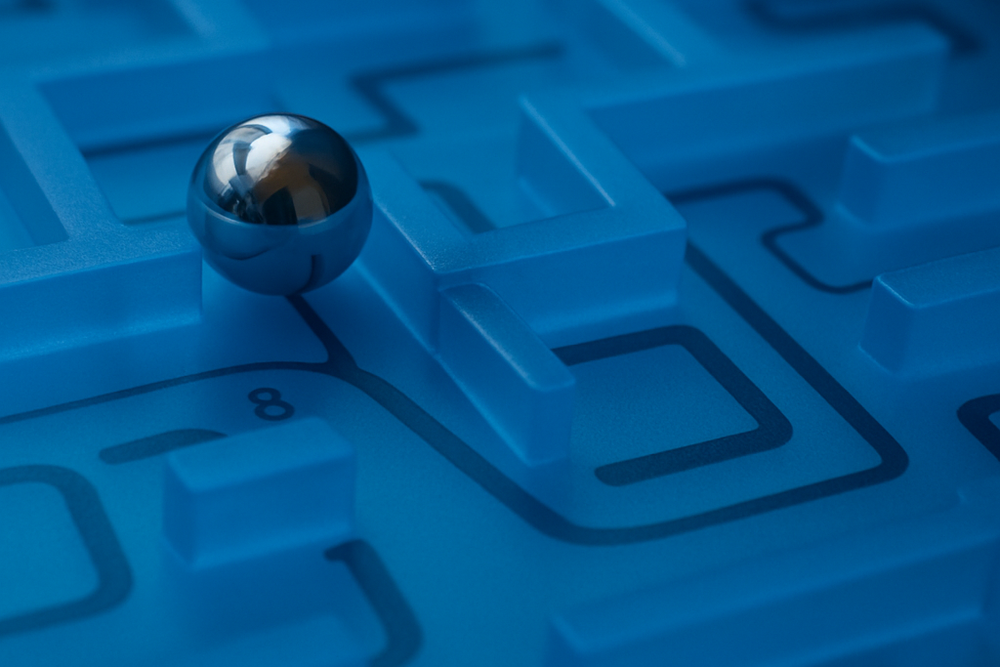 Metal ball in a maze made of frosted blue glass